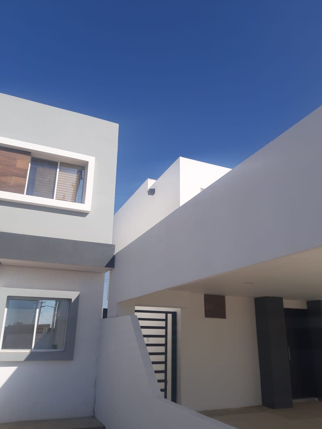 Patio y acceso lateral de la casa blanca