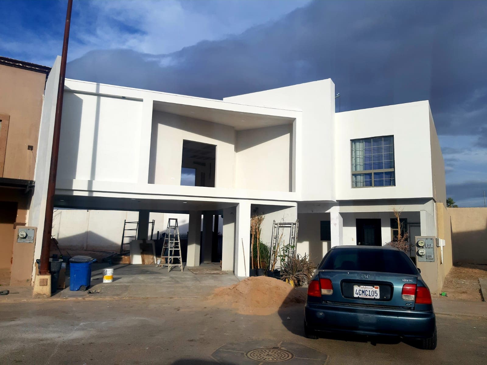 Fachada de la casa con terraza a doble altura en etapa de acabados