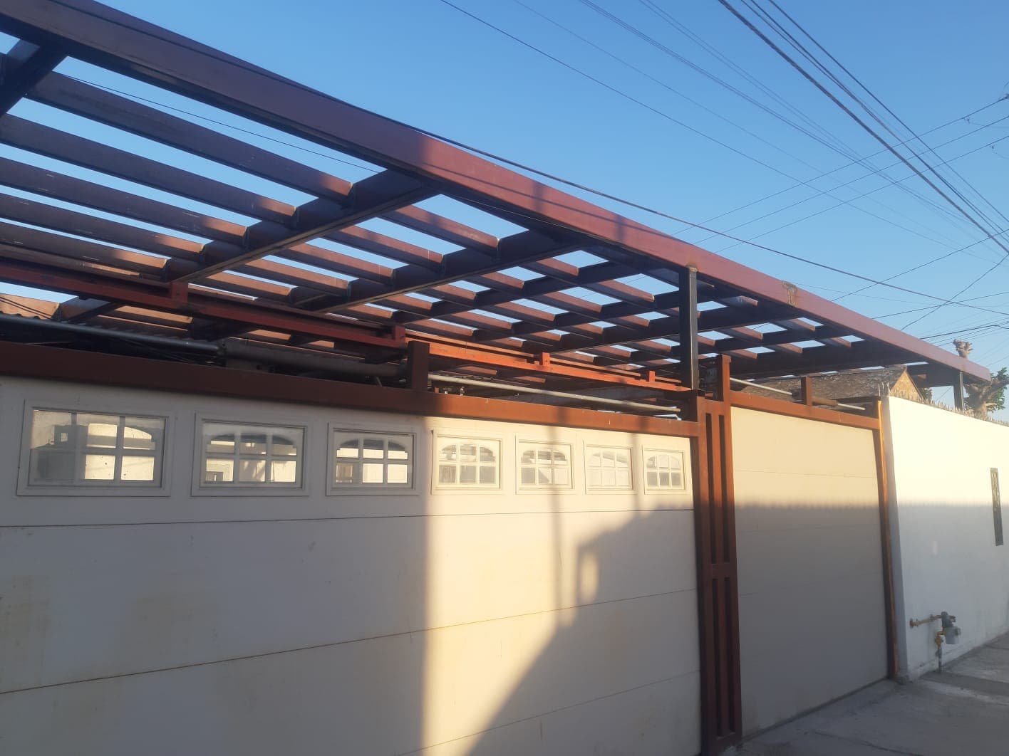 Pérgola de acero color caoba sobre la cochera